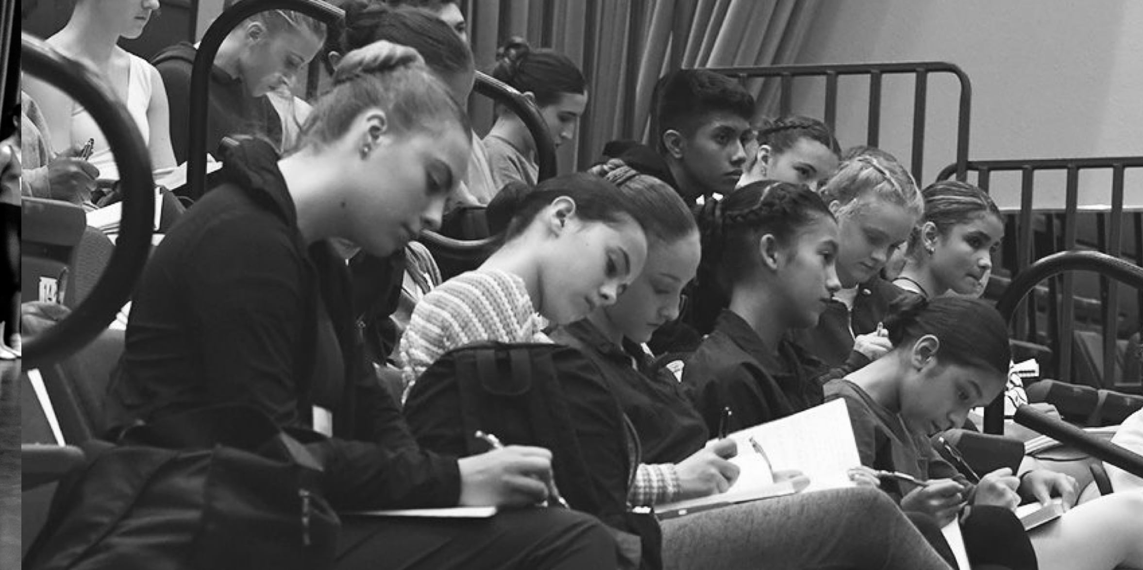 Dance students taking notes in class.